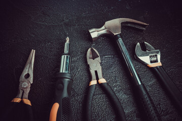 Many different tools for repair work on a black background