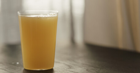orange juice with sparkling water in tumbler glass on black wood table with copy space