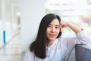 attractive adult business woman asian girl with happy and smile sitting at pole under her office on morning.