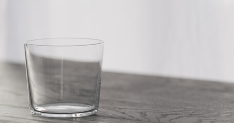 empty tumbler glass on black oak table