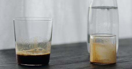 espresso in tumbler glass on black oak table