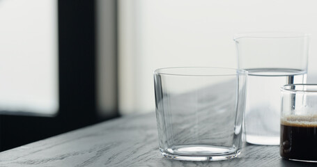 espresso in tumbler glass on black oak table