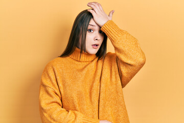 Young hispanic girl wearing casual clothes surprised with hand on head for mistake, remember error....