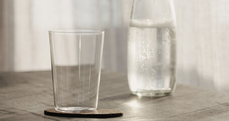 tumbler glass with bottle on black oak table
