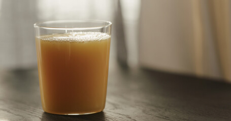 orange juice in tumbler glass on black wood table with copy space