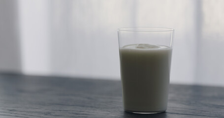 organic yogurt in tumbler glass on black wood table with copy space