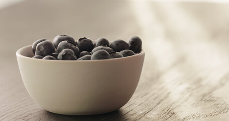 blueberries in white bowl on oak table