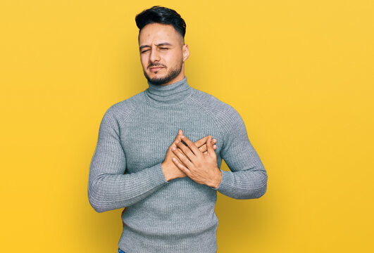 Young arab man wearing casual clothes smiling with hands on chest with closed eyes and grateful gesture on face. health concept.