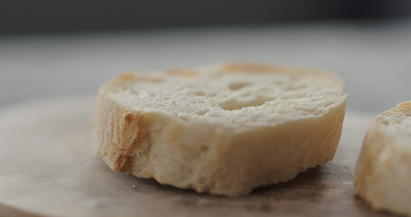 fresh baguette slice on olive board closeup