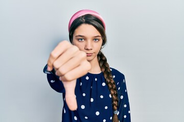 Young brunette girl wearing elegant look looking unhappy and angry showing rejection and negative with thumbs down gesture. bad expression.