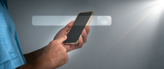 Fototapeta premium The businessman working with a mobile phone in the office. The concept is Search engine Browsing Internet Data Information with a blank search bar. Search Engine SEO Networking.