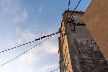 Tower with electric cables stretched out in various directions, with the blue sky in the background.