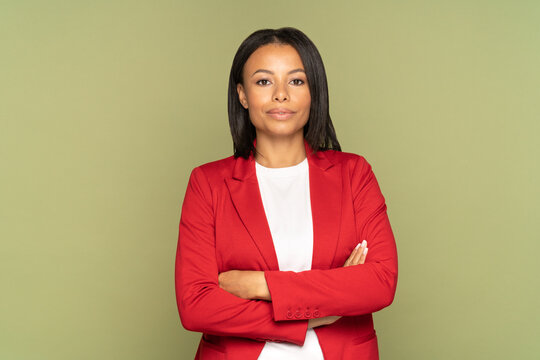 Confident african american businesswoman studio portrait with folded hands. Successful young girl entrepreneur wearing elegant red jacket isolated over empty wall. Female leader and leadership concept - Powered by Adobe