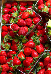 bright juicy ripe strawberries are sold in containers at the farmers' market close-up