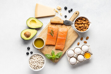 Assortment of healthy protein sources and body building food : fish, vegetables, legumes, nuts, cereals and dairy products on a light slate, stone or concrete background. Top view, copy space