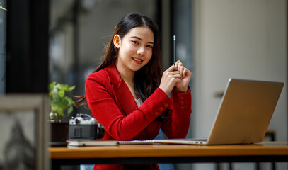 Shot of an Asian young business Female working on laptop computer in her workstation.Portrait of Business people employee freelance online marketing e-commerce telemarketing concept.