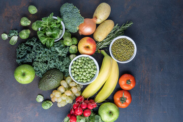 The concept of a healthy vegetarian diet, a selection of fresh products for a detox diet, raw broccoli, apple, spinach, peas, avocado, lime, corn salad, top view. The concept of healthy eating.
