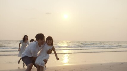 Group asia people dad mom and baby boy son and girl enjoy life good warm time run at sea with gold dusk dawn sky in slow motion. Active two small cute little child smile laugh fun trip after covid. - Powered by Adobe