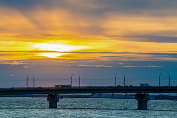 Obraz premium Transport moves across the bridge at sunset