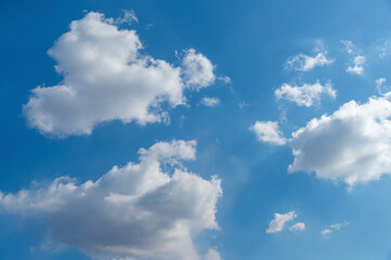 Obraz premium White Cumulus clouds in a bright blue sky.
