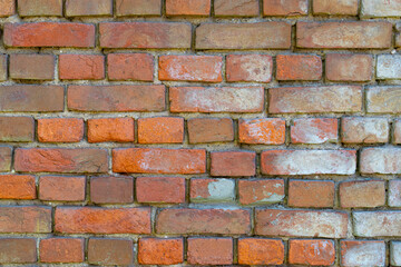 Old wall made of bricks of different colors