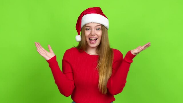Teenager girl with christmas hat with surprise and shocked facial expression over isolated background. Green screen chroma key