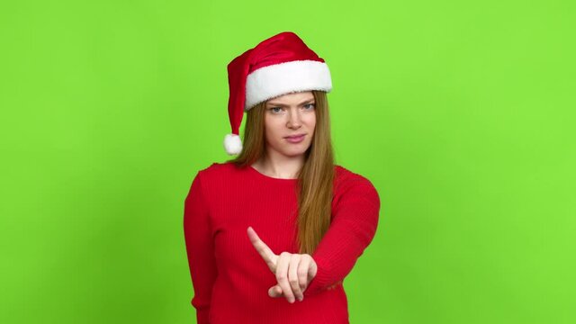 Teenager girl with christmas hat doing NO gesture over isolated background. Green screen chroma key