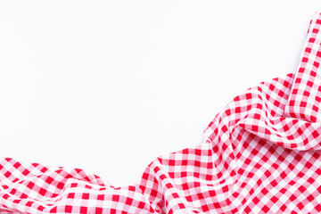 Checkers fabric crumpled top view with copy space. Red and white tablecloth texture on white background.