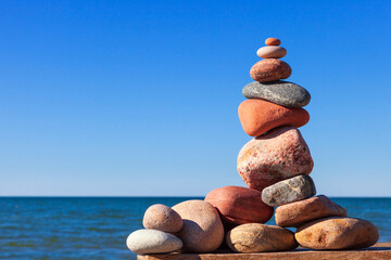 Rock zen pyramid of colorful pebbles on the background of the sea. Concept of Life balance
