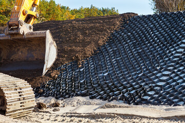 Polymer geogrid for filled with soil. Strengthening of sandy slopes with a geogrid