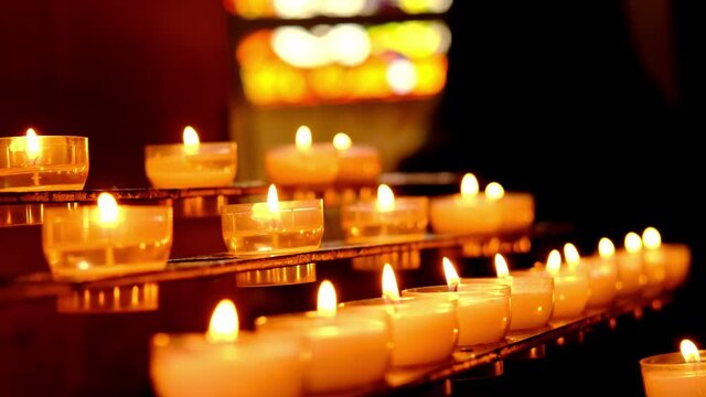 close-up of many candles burning in the dark, church decoration, bell ringing, the concept of Christian religious beliefs, praying for the health or peace of the soul