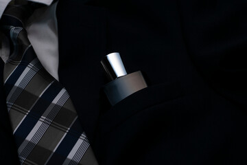 men's suit with a tie and perfume in a jacket pocket