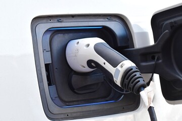 Closeup of a white electric car being charged