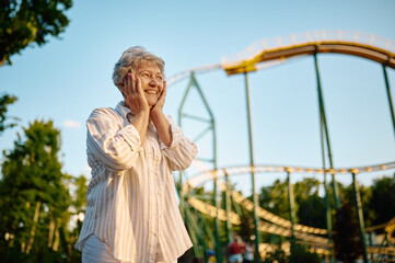Pretty granny poses in summer amusement park