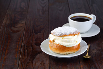 Swedish dessert Semla or Shrove bun, with almond paste and whipped cream filling, horizontal, copy...