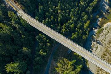 Drone shot of a bridge over river bed and a forest