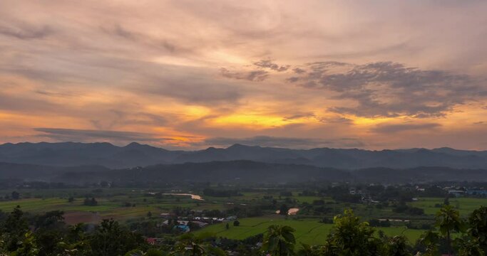 Time lapse Sunset to dusk sky oer the hillside village with agriculture fields at Mae Hong Son province Northern Thailand.