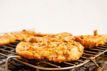 Close-up of chicken steaks on a garden electric grill. Isolated on white background.