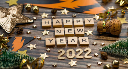 Banner.A symbol from the number 2022 with golden balls, stars, sequins and Christmas trees on a wooden background. The concept of celebrating a happy New year and Christmas.