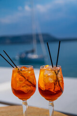 Orange drink or cocktail standing at the little table at the restaurant or cafe with sea background