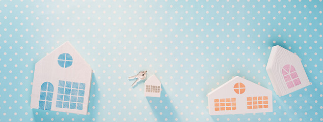 White toy houses on a blue with white polka dot background