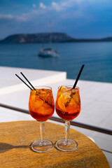 Orange drink or cocktail standing at the little table at the restaurant or cafe with sea background