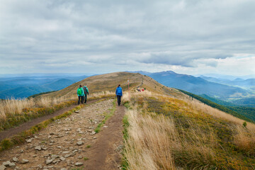 Bieszczady jesienią. Turyści na górskich szlakach. Połoniny. Ciemne chmury. Korory jesieni. © Tomasz