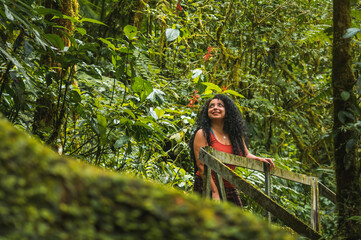 Young Latina girl vacationing and exploring alone a beautiful primary tropical rain forest in a national park of Costa Rica