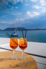 Orange drink or cocktail standing at the little table at the restaurant or cafe with sea background