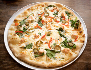 Pizza is on the plate on the wooden table 