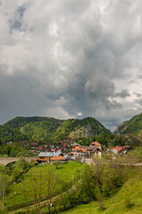 Fototapeta na wymiar Ancient village among the Romanian Carpathian mountains with a storm about to fall on the ground