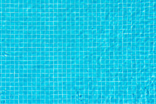 Calm blue water in the pool. You can clearly see the squares from the tiles at the bottom. Copy space.