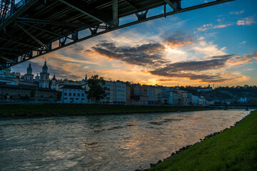 Fototapeta premium Mozartsteg in the city of salzburg at sunset with clouds over river salzach