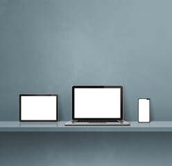 Laptop, mobile phone and digital tablet pc on grey wall shelf. Square background